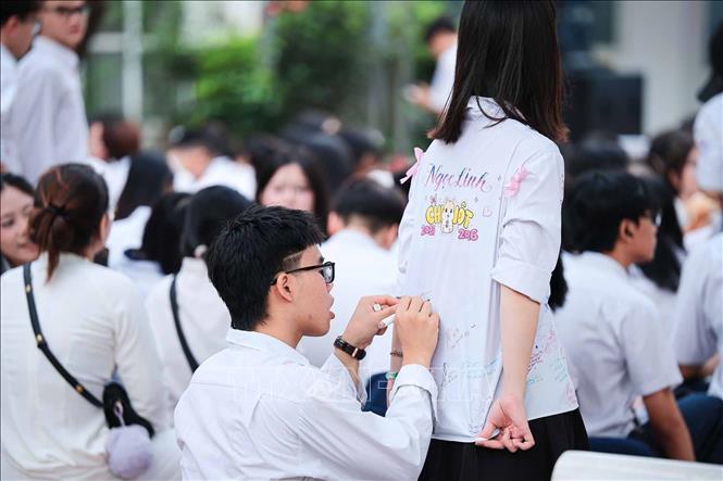 Những dòng lưu bút kín dần trên tà áo trắng như cách học sinh lưu giữ thanh xuân cuối cùng dưới mái trường THPT Đoàn Kết – Hai Bà Trưng. Ảnh: Phạm Tuấn Anh - TTXVN