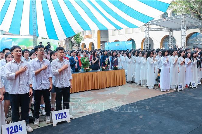 Các đại biểu, Ban hiệu nhà trường cùng học sinh trường THPT Việt Đức thực hiện nghi thức chào cờ. Ảnh: Lê Đông - TTXVN