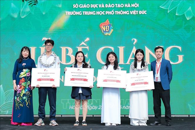 Nhà giáo, TS Nguyễn Bội Quỳnh, Bí thư Đảng ủy, hiệu trưởng trường THPT Việt Đức và thầy Nguyễn Vũ Hoàng Phương, Trưởng phòng tuyển sinh trường Đại học Anh Quốc Việt Nam (BUV) trao học bổng cho những học sinh có thành tích suất sắc. Ảnh: Lê Đông - TTXVN