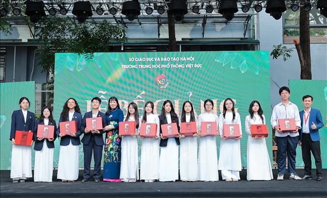 Nhà giáo, TS Nguyễn Bội Quỳnh, Bí thư Đảng ủy, hiệu trưởng trường THPT Việt Đức và thầy Nguyễn Vũ Hoàng Phương, Trưởng phòng tuyển sinh trường Đại học Anh Quốc Việt Nam (BUV) trao quà cho những học sinh có thành tích tiêu biểu. Ảnh: Lê Đông - TTXVN