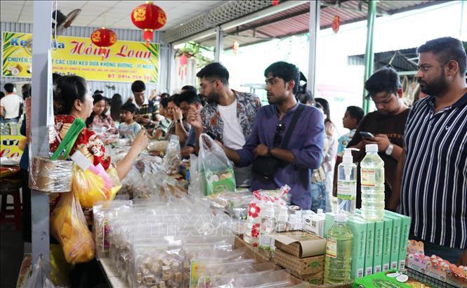 Khách nước ngoài tham quan gian hàng trưng bày sản phẩm OCOP tại một điểm du lịch ở phường Mỹ Tho, tỉnh Đồng Tháp. Ảnh: Hữu Chí - TTXVN