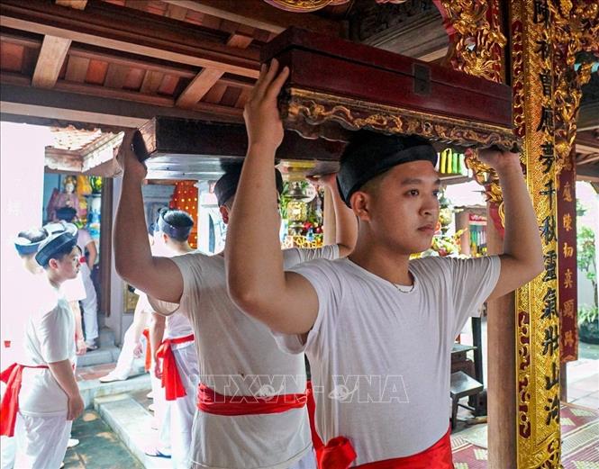 Các trai rước kiệu chuẩn bị cho nghi thức rước. Ảnh: Khánh Hoà - TTXVN