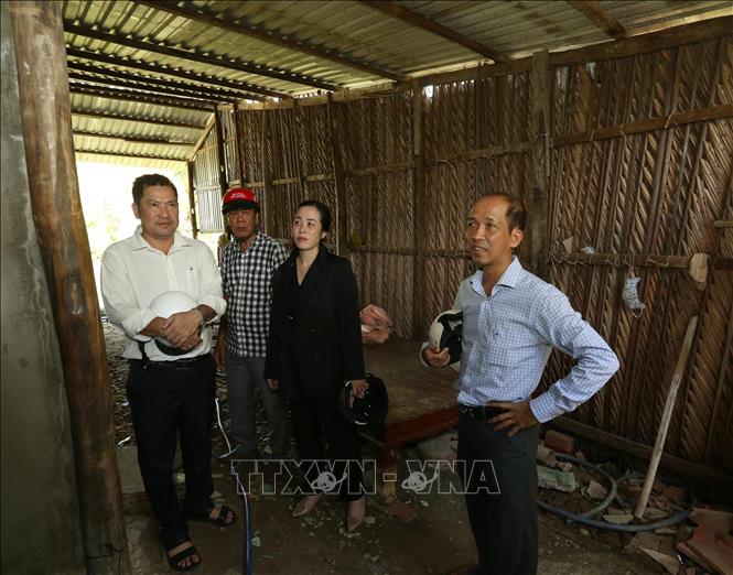 Bí thư Đảng ủy, Chủ tịch HĐND xã Nguyễn Huy Cường (giữa) và đồng chí Chủ tịch UBND xã Đào Thị Loan Anh (trái) đi thăm thực tế gia đình hộ nghèo. Ảnh: Duy Khương – TTXVN 