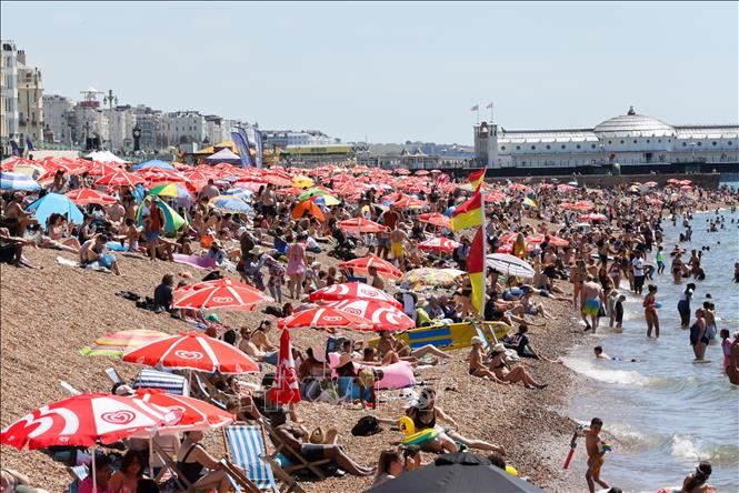 Người dân tránh nóng trên bãi biển ở Brighton, Anh. Ảnh: THX/TTXVN