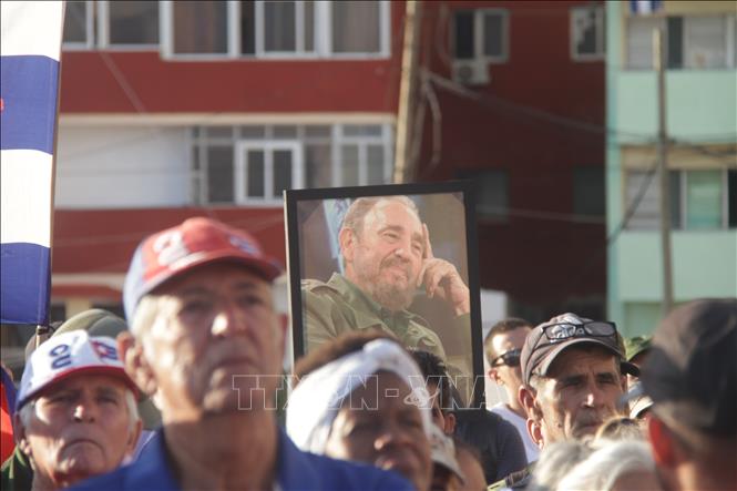 Người dân giơ cao hình ảnh lãnh tụ Fidel Castro trong cuộc mít tinh ở thủ đô La Habana. Ảnh: Ngọc Duy - PV TTXVN tại Cuba