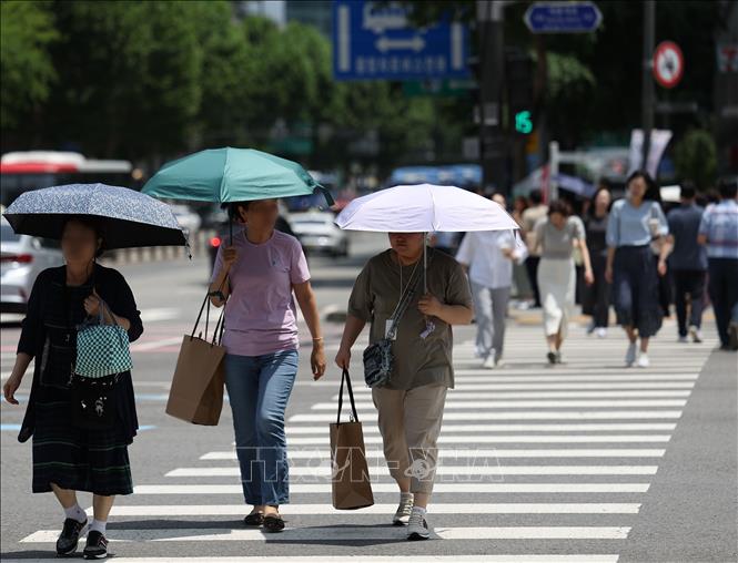 Người dân che ô tránh nắng nóng tại Seoul, Hàn Quốc. Ảnh: Yonhap/TTXVN
