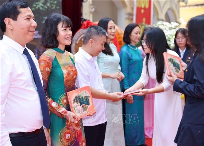 Học sinh khối 12 dành tặng tới thầy cô cuốn kỷ yếu nhỏ mang dấu ấn của ba năm học tập dưới mái trường Chu Văn An. Ảnh: Thanh Tùng - TTXVN