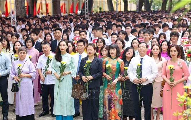 Trước buổi bế giảng, tập thể Hội đồng sư phạm nhà trường cùng các bậc phụ huynh và học sinh đã dâng hoa tượng đài Thầy Chu Văn An. Ảnh: Thanh Tùng  - TTXVN