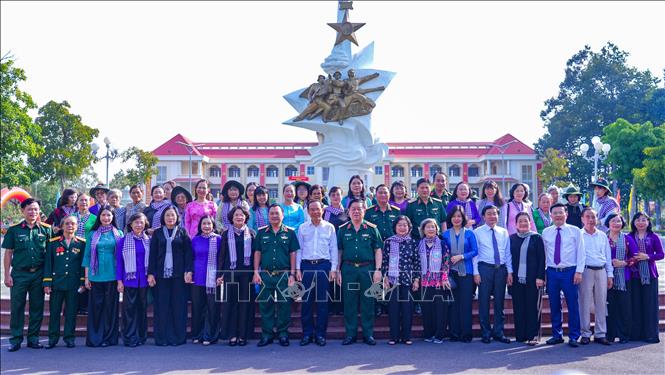 Các đại biểu chụp ảnh lưu niệm tại Đài tưởng niệm và Nhà bia ghi danh các Anh hùng liệt sĩ của Sư đoàn Bộ binh 5 (Quân khu 7). Ảnh: Minh Phú - TTXVN 