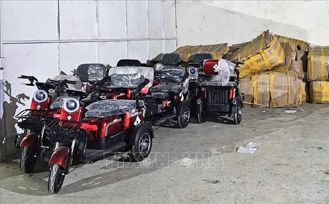 Tất cả xe điện dạng ba bánh này đều tập kết trong kho nhưng không có hóa đơn, chứng từ, hồ sơ nhập khẩu theo quy định. Ảnh: TTXVN phát 