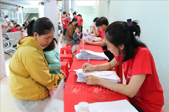 Cha mẹ đưa trẻ đến thăm khám tại chương trình. Ảnh: TTXVN phát