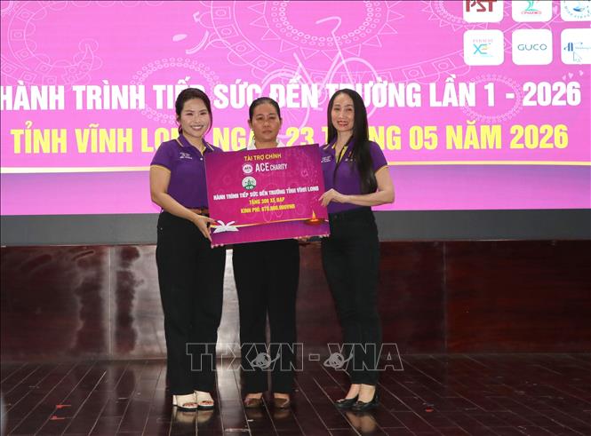 Trao bảng tượng trưng kinh phí hỗ trợ xe đạp cho học sinh. Ảnh: Lê Thúy Hằng – TTXVN