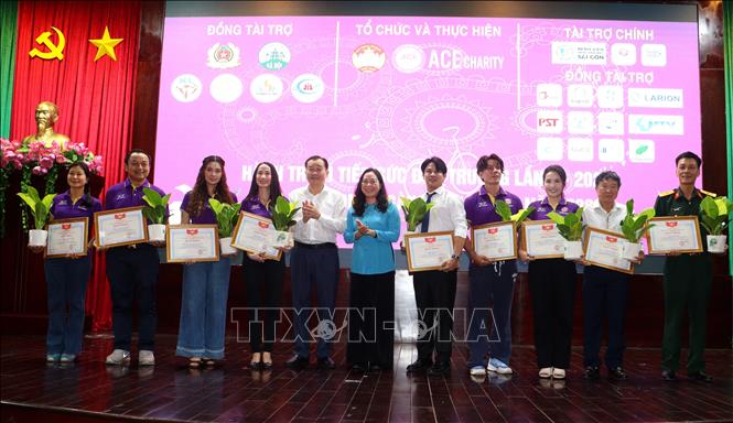 Trao bằng khen của Chủ tịch UBND tỉnh Vĩnh Long cho các đơn vị tài trợ. Ảnh: Lê Thúy Hằng – TTXVN