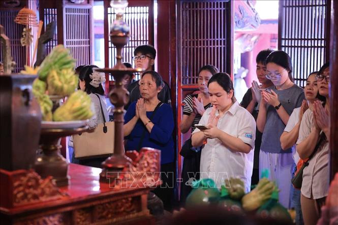 Nhiều phụ huynh và thí sinh đến Văn Miếu - Quốc Tử Giám nguyện cầu, mong việc học hành tấn tới, thi cử thuận lợi. Ảnh: Hoàng Hiếu - TTXVN