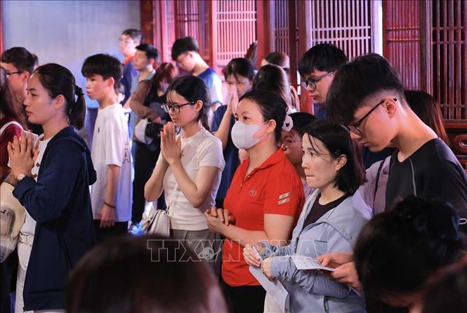 Nhiều phụ huynh và thí sinh đến Văn Miếu - Quốc Tử Giám nguyện cầu, mong việc học hành tấn tới, thi cử thuận lợi. Ảnh: Hoàng Hiếu - TTXVN