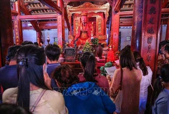 Nhiều phụ huynh và thí sinh đến Văn Miếu - Quốc Tử Giám cầu mong việc học hành tấn tới, thi cử thuận lợi. Ảnh: Hoàng Hiếu - TTXVN