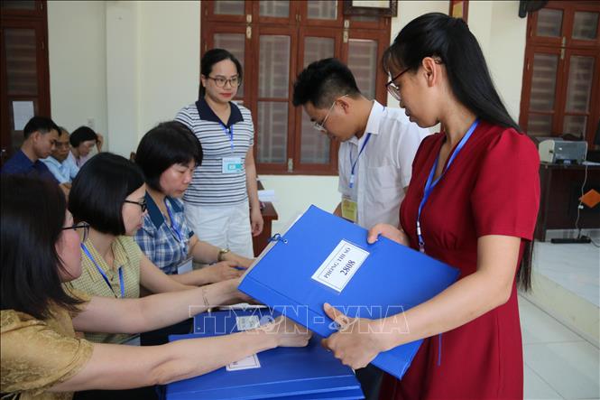 Giám thị tại điểm thi THPT Lê Quý Đôn (phường Trần Hưng Đạo, tỉnh Hưng Yên) nhận danh sách phòng thi. Ảnh: Thu Hoài - TTXVN