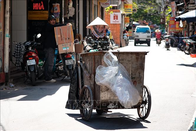 Người lao động làm việc dưới nắng nóng hầm hập, nhiệt độ có nơi trên 39 độ C. Ảnh: Hoài Nam-TTXVN