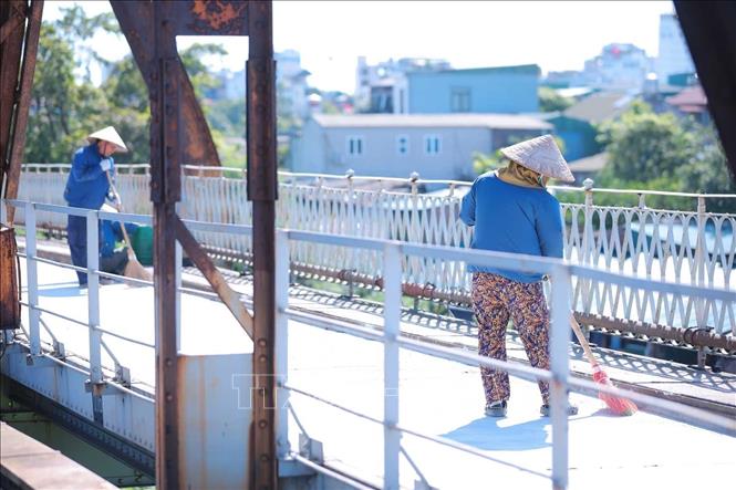 Công nhân đang khẩn trương hoàn thiện các hạng mục, dọn dẹp hiện trường, sẵn sàng thông xe cầu Long Biên vào ngày 27/5. Ảnh: Hoàng Hiếu - TTXVN