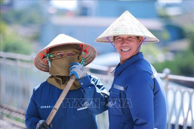 Những công nhân đang làm việc trên công trường cầu Long Biên trong cái nắng gay gắt giữa trưa 24/5. Ảnh: Hoàng Hiếu - TTXVN