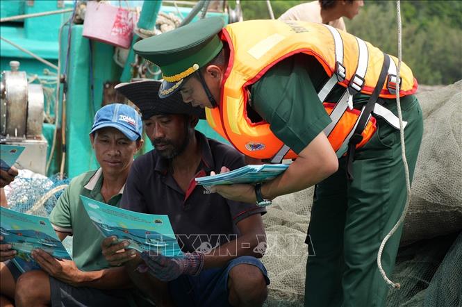 Cán bộ chiến sĩ Trạm kiểm soát Biên phòng Rạch Đầm, Đồn Biên phòng cửa khẩu An Thới (Ban Chỉ huy Bộ đội Biên phòng An Giang) tuyên truyền chống IUU cho ngư dân. Ảnh: Lê Huy Hải - TTXVN