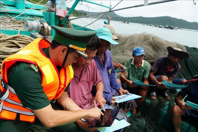 Cán bộ chiến sĩ Trạm kiểm soát Biên phòng Rạch Đầm, Đồn Biên phòng cửa khẩu An Thới (Ban Chỉ huy Bộ đội Biên phòng An Giang) tuyên truyền chống IUU cho ngư dân. Ảnh: Lê Huy Hải - TTXVN 