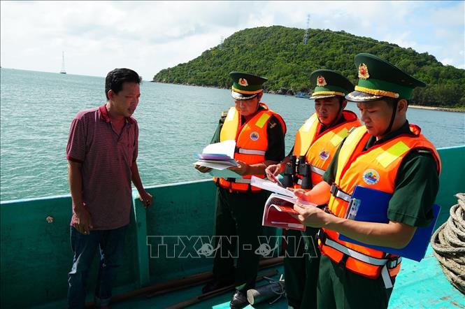 Cán bộ chiến sĩ Trạm kiểm soát Biên phòng Rạch Đầm, Đồn Biên phòng cửa khẩu An Thới (Ban Chỉ huy Bộ đội Biên phòng An Giang) kiểm tra hồ sơ tàu cá ngư dân. Ảnh: Lê Huy Hải - TTXVN 