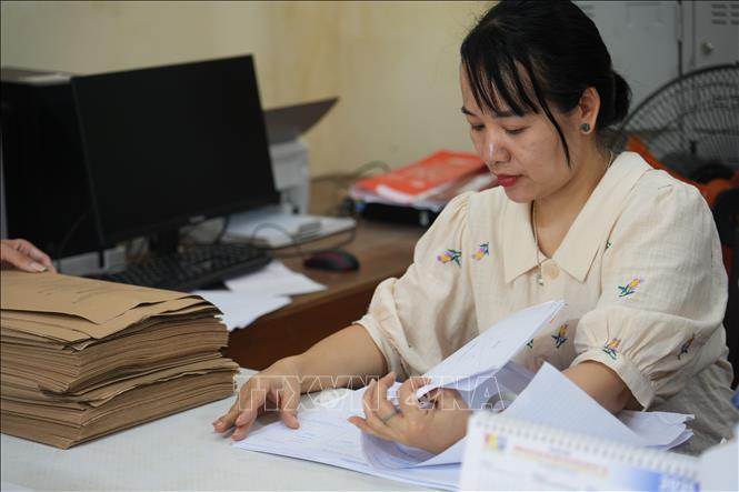 Kiểm tra lại hồ sơ của học sinh trước khi kỳ thi diễn ra. Ảnh: Bích Huệ - TTXVN