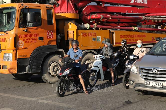Người dân tham gia giao thông trên địa bàn phường Hoa Lư ngày nắng nóng. Ảnh: Đức Phương - TTXVN