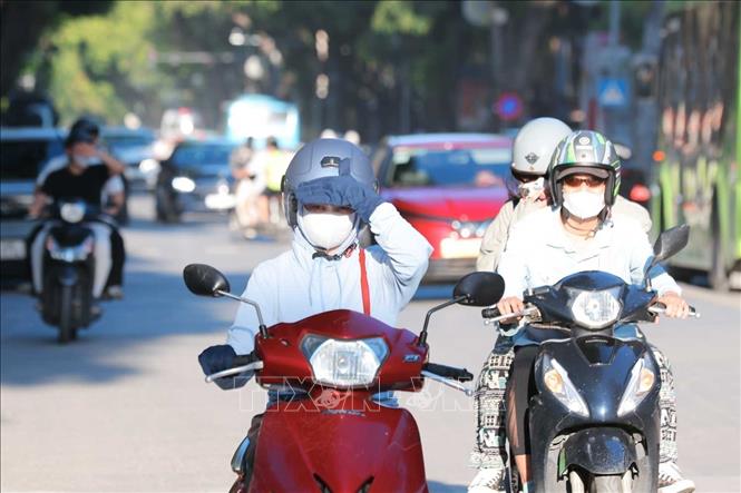 Ánh nắng chói chang lúc 17h34' khiến người đi trên đường Hai Bà Trưng hướng Lê Duẩn gặp nhiều khó khăn. Ảnh: Hoàng Hiếu - TTXVN