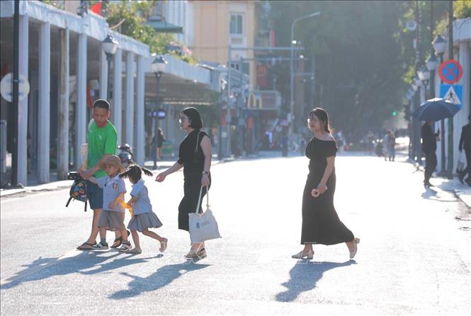 Đến 17h30', nhiệt độ cao cùng nắng chói chang khiến đường Tràng Tiền vắng bóng người qua lại. Ảnh: Hoàng Hiếu - TTXVN