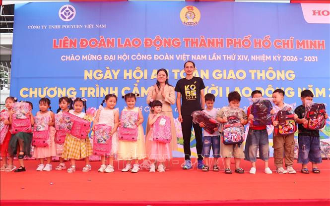 Lãnh đạo chính quyền địa phương trao quà cho con em người lao động tại Ngày hội “An toàn giao thông” và Chương trình “Cảm ơn người lao động”. Ảnh: Thanh Vũ - TTXVN