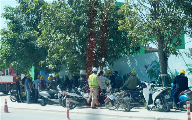 Người lao động tận dụng bóng cây để nghỉ giải lao giữa trời nắng nóng gay gắt. Ảnh: Văn Đức - TTXVN