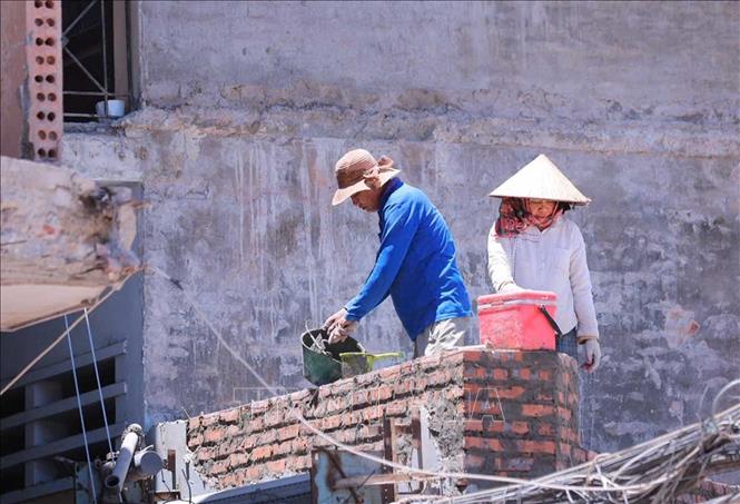 Người lao động làm việc ngoài trời khi thời tiết. Ảnh: Hoàng Hiếu - TTXVN