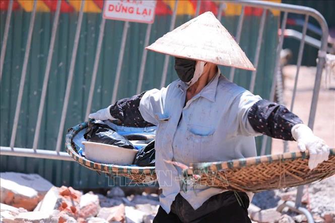 Người lao động vẫn phải chật vật mưu sinh khi nhiệt độ Hà Nội tăng cao, có lúc nhiệt độ ngoài trời. Ảnh: Hoàng Hiếu - TTXVN