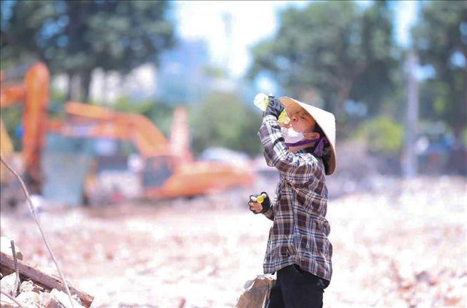 Nhiệt độ ngoài trời tăng cao, người lao động phải chật vật mưu sinh. Ảnh: Hoàng Hiếu - TTXVN 