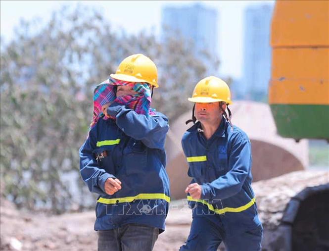 Người lao động phải cố chống chịu nắng nóng khi phải làm việc ngoài trời (ảnh chụp lúc 11h05'). Ảnh: Hoàng Hiếu - TTXVN