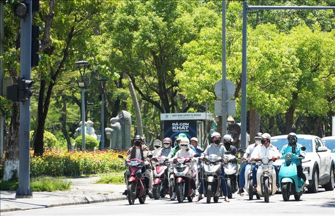 Người dân mặc đồ bảo hộ tránh nắng nóng gay gắt khi tham gia giao thông trên đường Lê Lợi, phường Thuận Hóa (Huế). Ảnh: Nguyên Lý-TTXVN