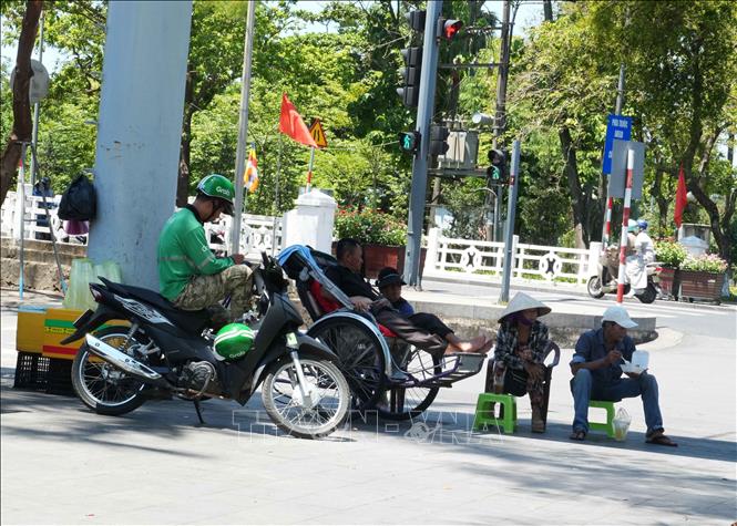 Tránh nắng nóng gay gắt dưới bóng mát trên đường Trần Hưng Đạo, phường Phú Xuân (Huế). Ảnh: Nguyên Lý-TTXVN