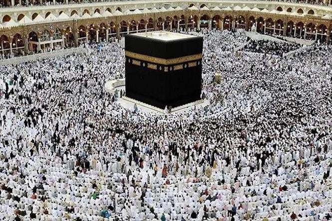 Các tín đồ Hồi giáo trong trang phục truyền thống đi vòng quanh khối đá thiêng Kaaba tại Thánh địa Mecca. Ảnh: IRNA/TTXVN  
