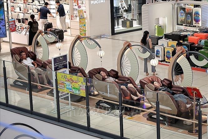 Khu vực ghế massage tại trung tâm thương mại thu hút nhiều người nghỉ ngơi, thư giãn trong không gian điều hòa mát mẻ. Ảnh: Phạm Tuấn Anh - TTXVN