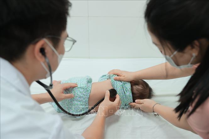 Bác sĩ bệnh viện đa khoa Xanh Pôn khám cho bệnh nhi. Ảnh: Minh Quyết – TTXVN