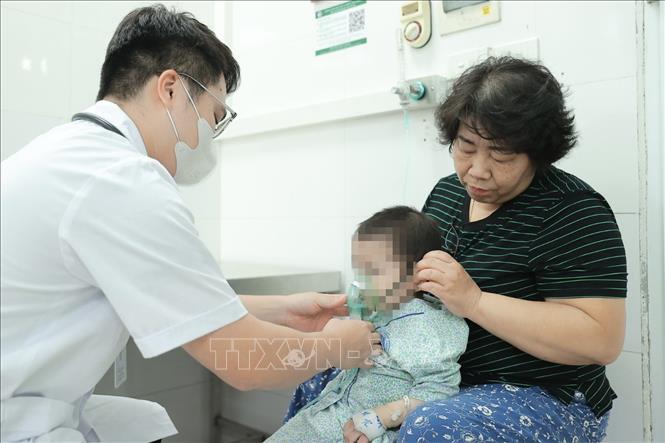 Bác sĩ bệnh viện đa khoa Xanh Pôn khám cho bệnh nhi. Ảnh: Minh Quyết – TTXVN