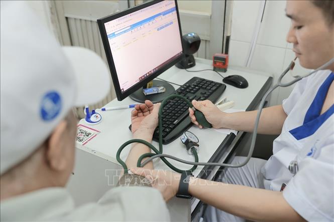 Bác sĩ bệnh viện đa khoa Xanh Pôn khám cho bệnh nhân người cao tuổi. Ảnh: Minh Quyết - TTXVN
