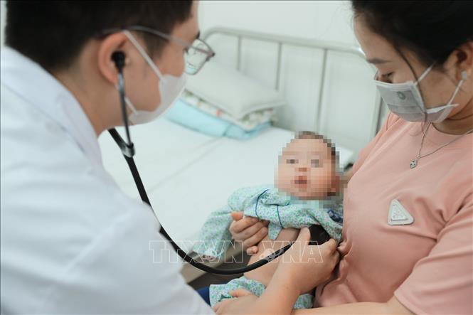 Bác sĩ bệnh viện đa khoa Xanh Pôn khám cho bệnh nhi. Ảnh: Minh Quyết – TTXVN