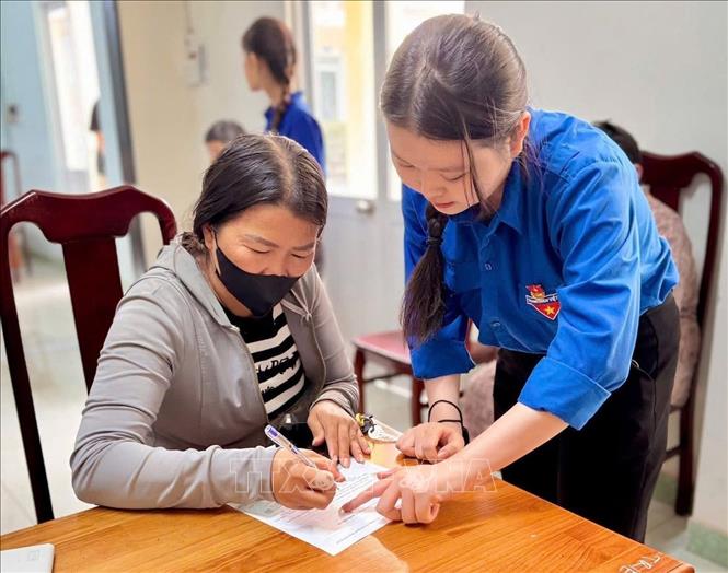 Tình nguyện viên đoàn thanh niên Trường Đại học Khánh Hòa hỗ trợ người dân làm thủ tục hành chính tại trung tâm hành chính xã, phường của tỉnh Khánh Hòa. Ảnh: Phan Sáu - TTXVN