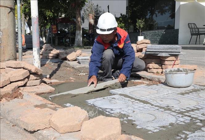 Công nhân thi công công trình giao thông phải làm việc dưới nền nhiệt cao, quần áo ướt đẫm mồ hôi giữa trưa nắng. Ảnh: Tạ Toàn – TTXVN