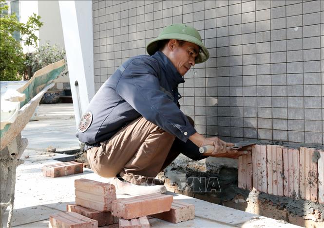 Để chống chọi cái nóng ngoài trời, nhiều lao động tự do đã tự trang bị áo gắn quạt làm mát. Ảnh: Tạ Toàn – TTXVN