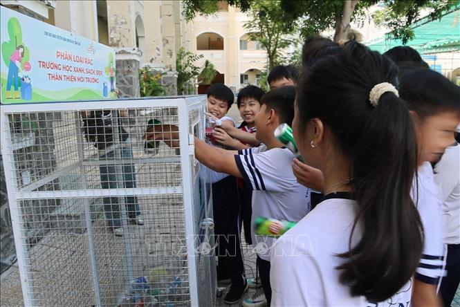 Học sinh trường Tiểu học Cần Thạnh 2, xã Cần Giờ (Thành phố Hồ Chí Minh) gom rác vào thùng phân loại rác. Ảnh: Hồng Đạt - TTXVN