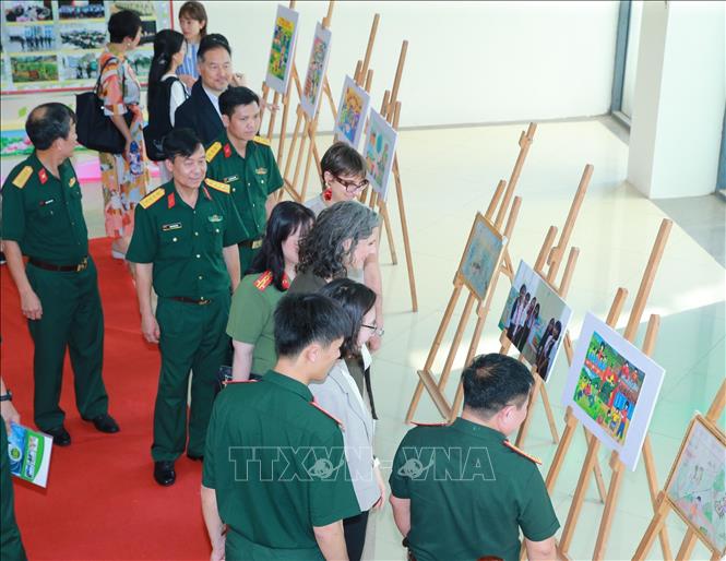 Các đại biểu tham quan triển lãm ảnh về hoạt động phòng tránh bom mìn ở Việt Nam. Ảnh: Trọng Đức - TTXVN